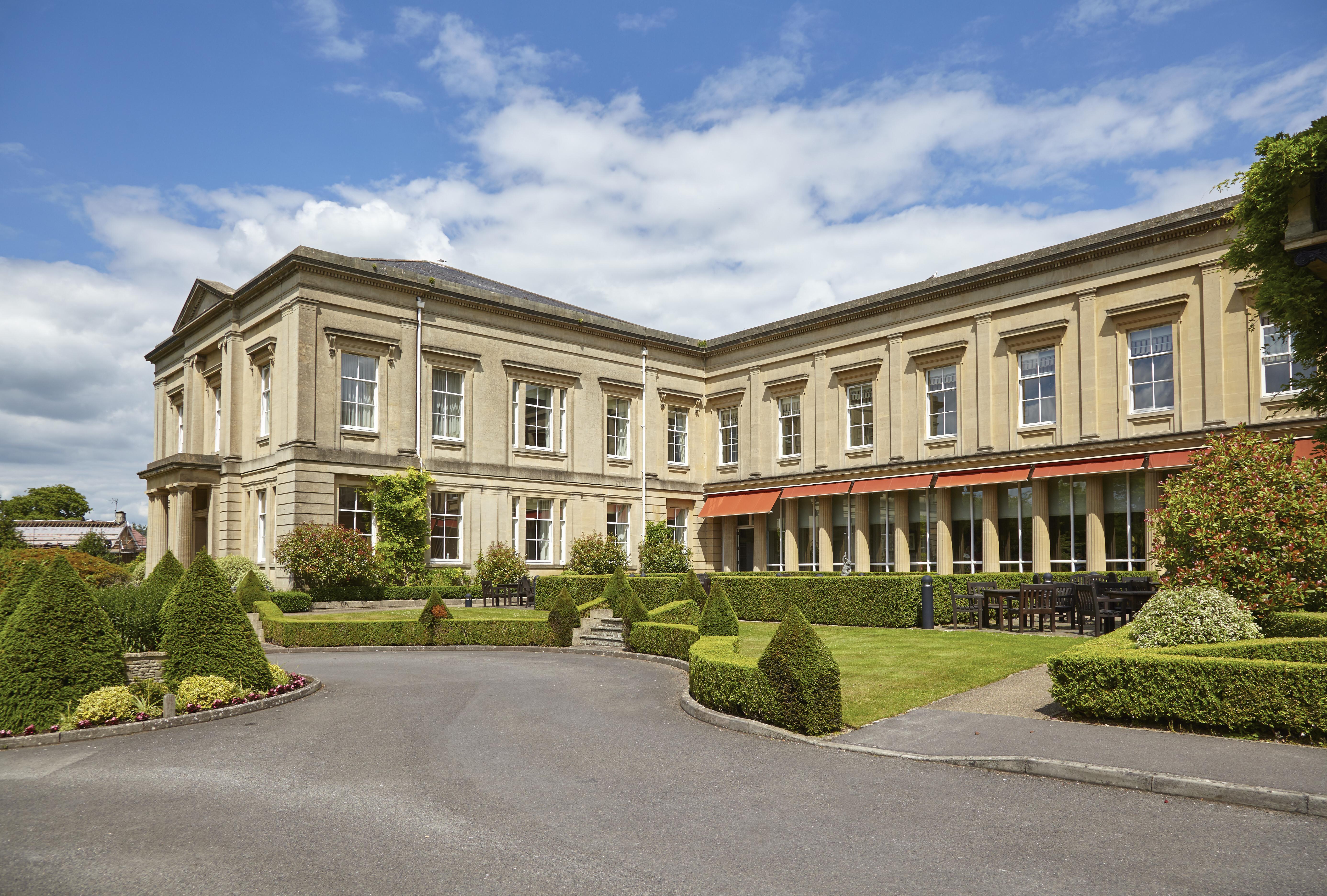 Macdonald Bath Spa Hotel Exterior foto The photo depicts a large, elegant building with a classic architectural style, featuring a combination of stone and large windows. The structure appears to have two sections: a main, stately part on the left and an adjoining section that has a terra